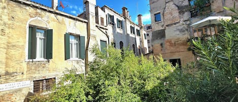 A narrow street with old buildings, some with visible chimneys and satellite dishes.
