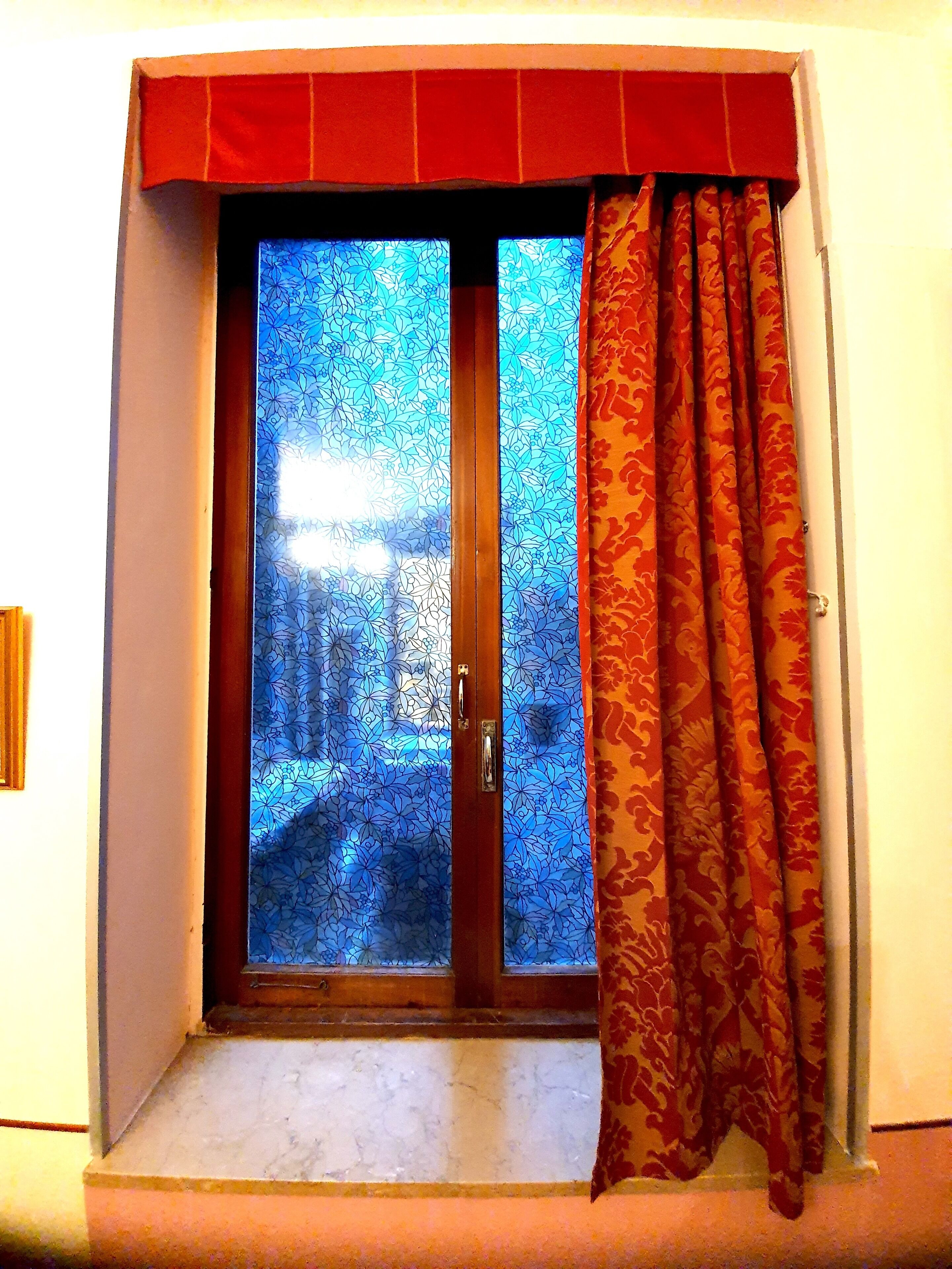 A room with a sliding glass door leading to a street view.