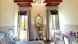 A bedroom with a bed, a desk, a chair, a mirror, and a chandelier. - Residenza degli Angeli (Venice)
