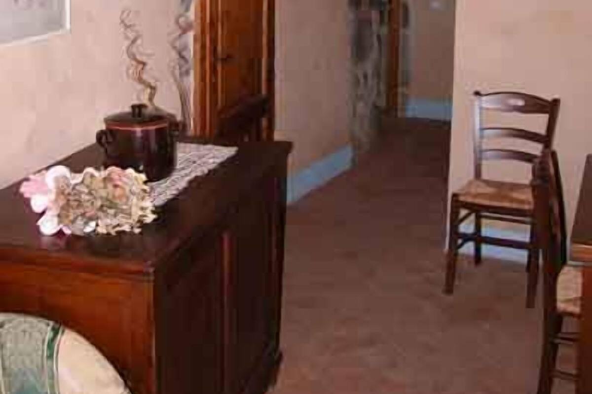 A room with a wooden desk, a chair, a cabinet, and a painting on the wall.