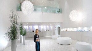 A spacious lobby with a high ceiling, large potted plants, and modern lighting fixtures. - Hotel Neptun – Lifeclass Hotels & Spa, Portorož (Piran)