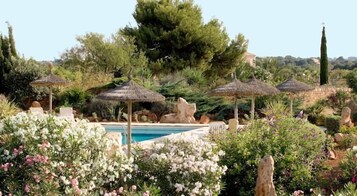 Una piscina al aire libre, sombrillas, sillones reclinables de piscina