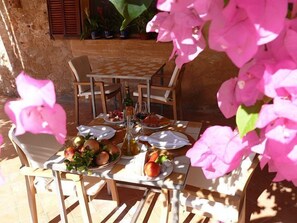 An outdoor dining area with a table set for two, surrounded by chairs. - Hotel Sa Carrotja - Adults Only (Ses Salines)
