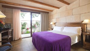 Une chambre d’hôtel avec un lit, un bureau avec une télévision et une vue sur l’extérieur.