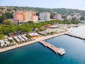 A waterfront hotel with multiple buildings, a dock, and outdoor seating by the water. - Hotel Riviera - LifeClass Hotels & Spa (Piran)