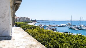 A marina with boats docked, a clear sky, and buildings in the background. - L'Approdo delle Sirene (Syracuse)