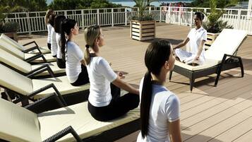 Una terrazza con lettini e una persona che medita.