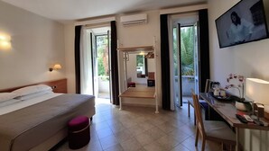 A hotel room with a bed, desk, chair, and a view of the outdoors. - Hotel Principe Eugenio (Rome)