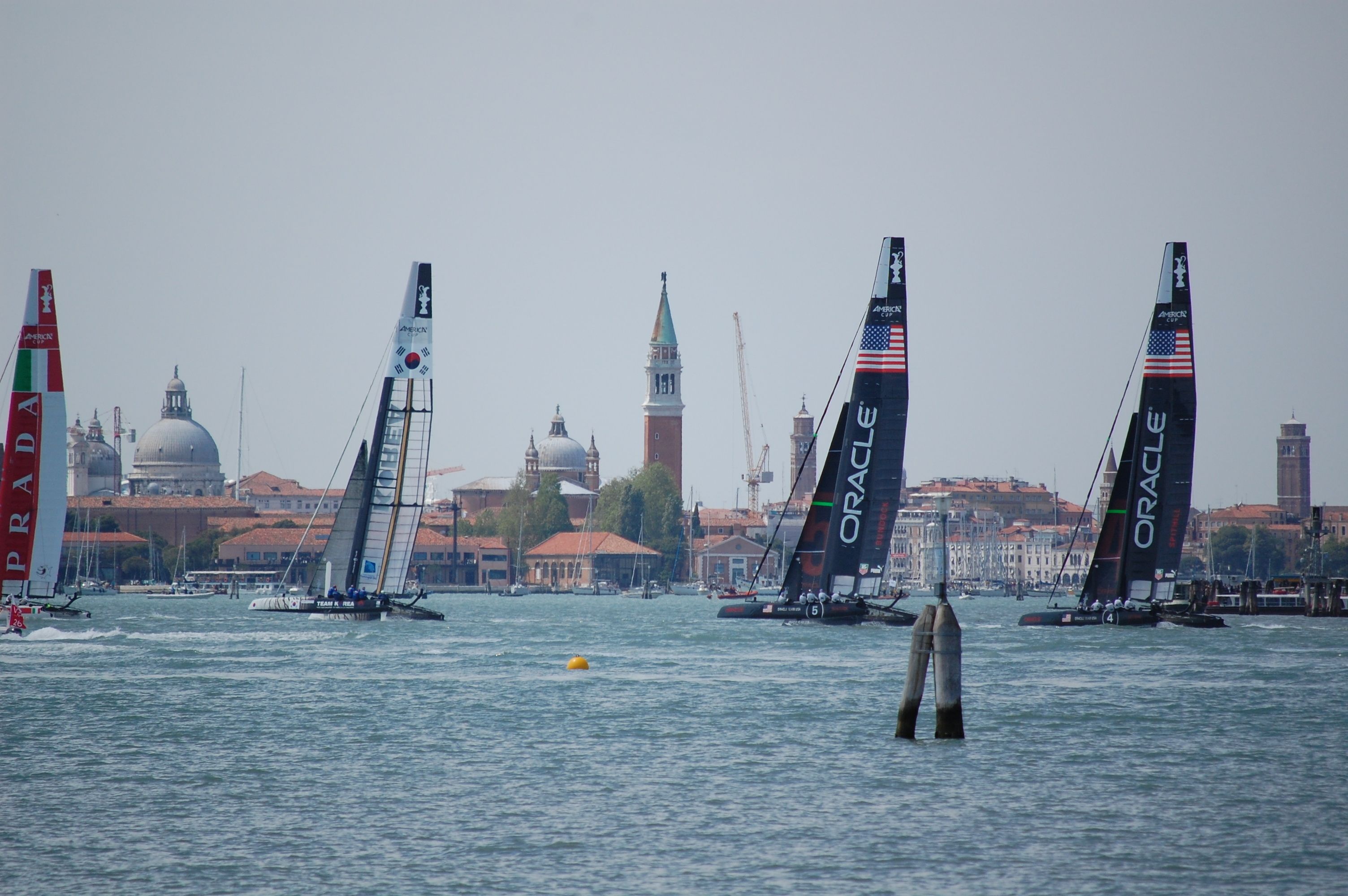 A harbor with sailboats and a cityscape in the background.