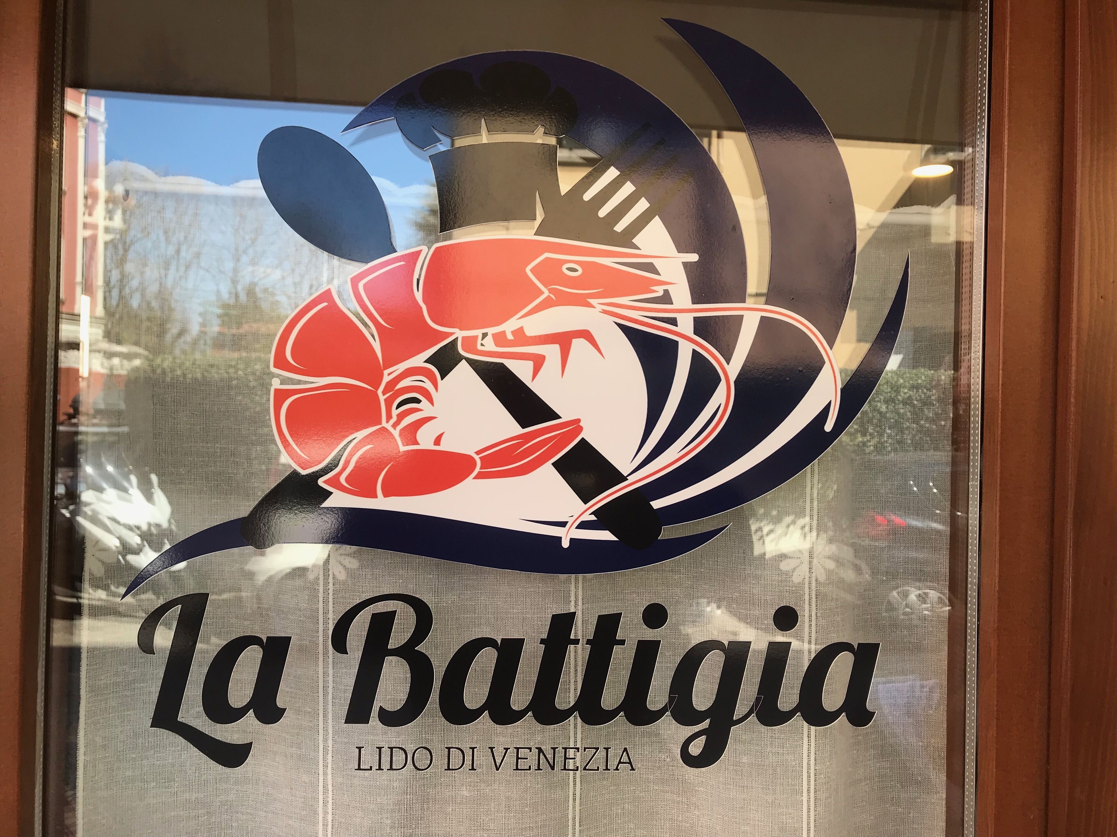 A logo with a lobster and the text "La Battigia LIDO DI VENEZIA".
