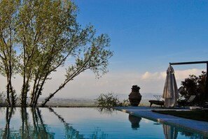 An infinity pool with a clear view of the sky and distant mountains.