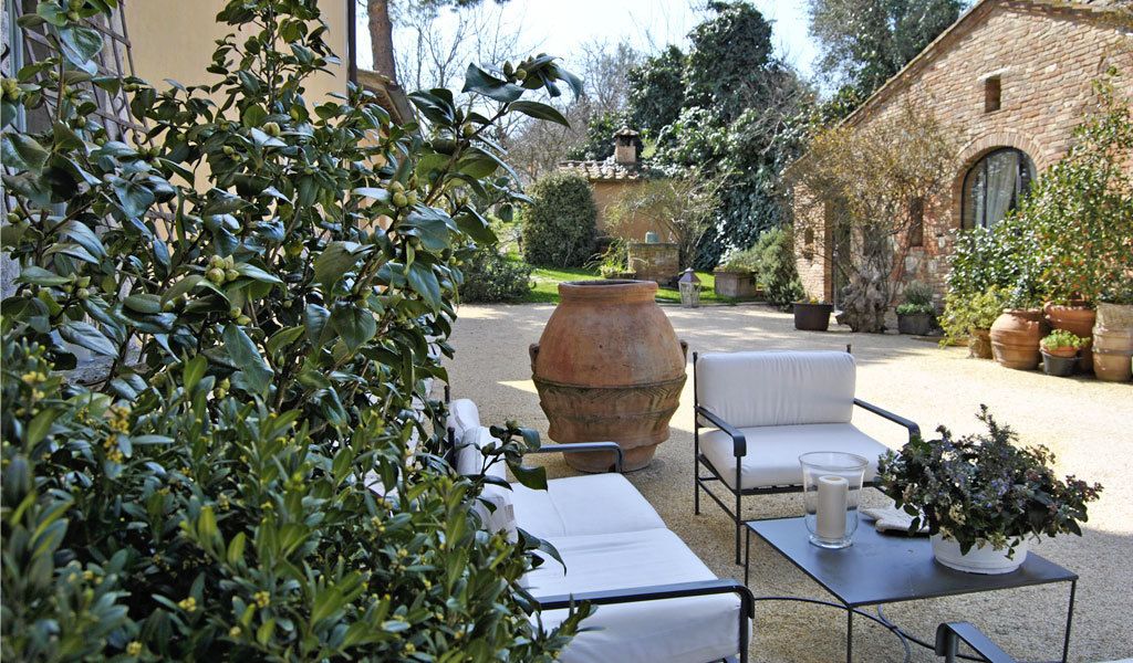 An outdoor seating area with a table, chairs, and potted plants.