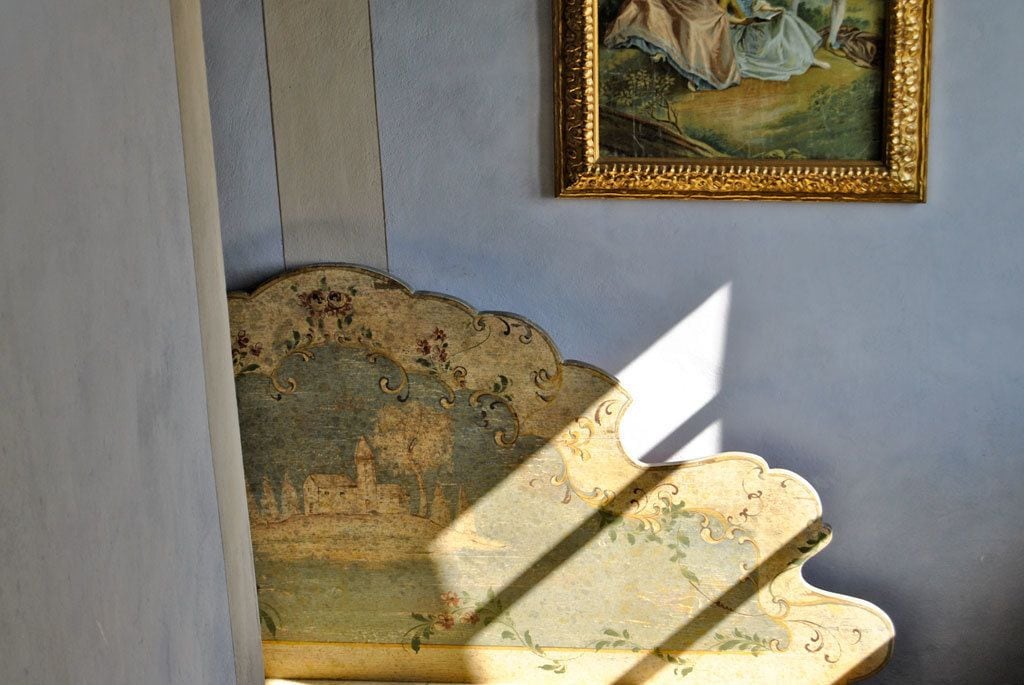 A room with a decorative wall panel and a framed painting.