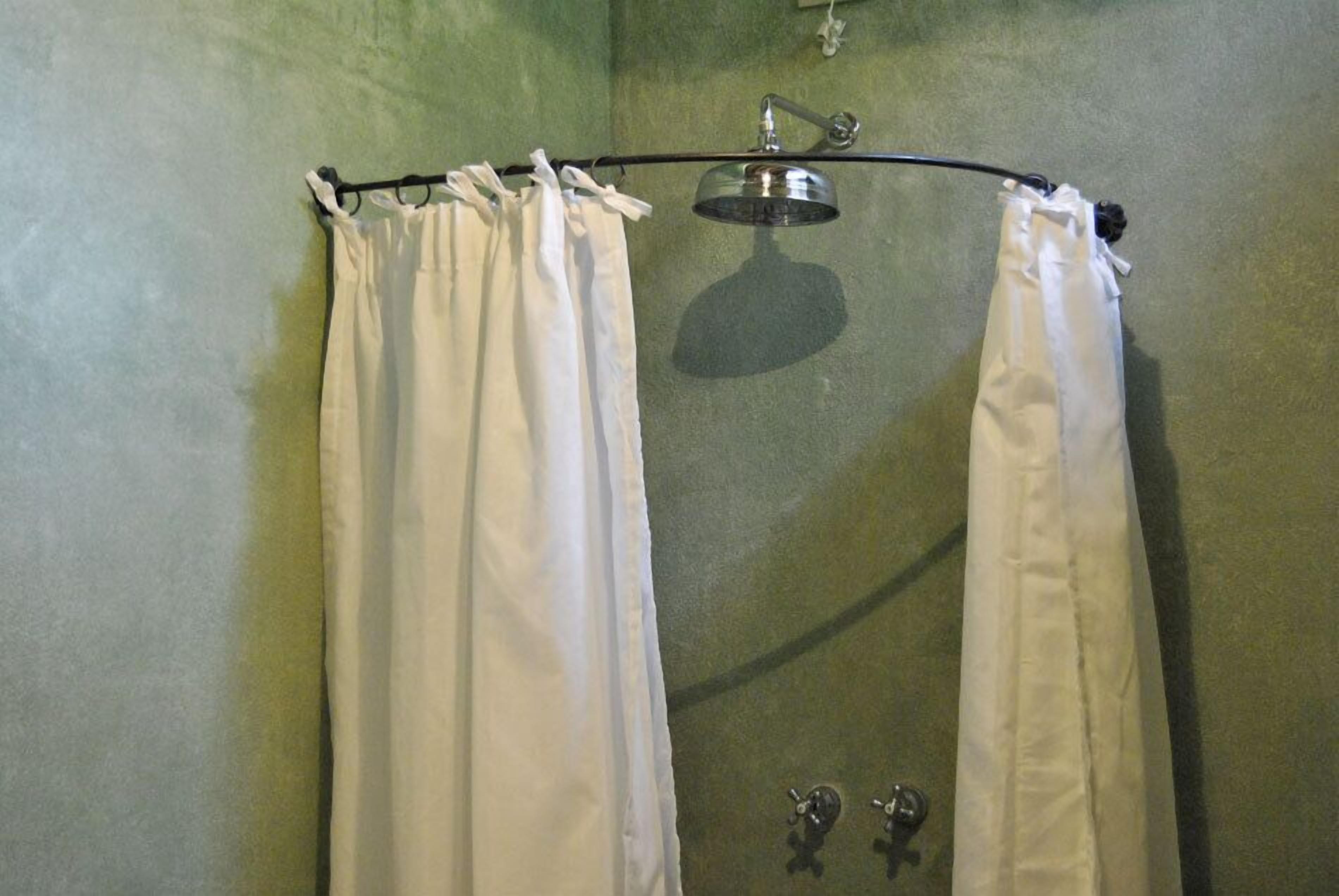 Un espace douche équipé d’un rideau de douche et d’un pommeau de douche amovible.