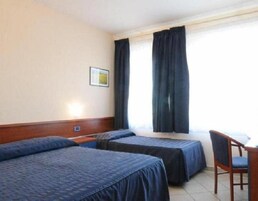 Una habitación de hotel con dos camas, un escritorio y una silla.