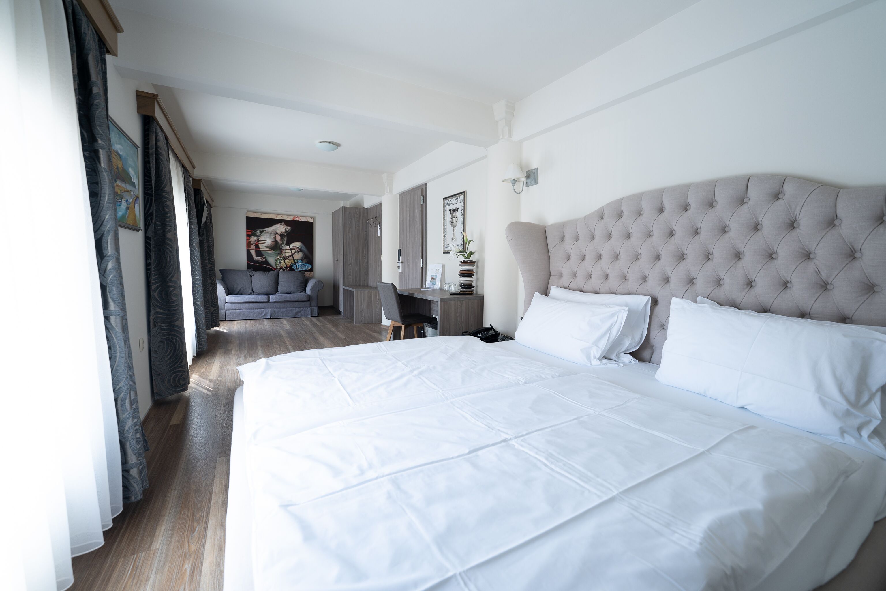 Una habitación de hotel moderna con una cama grande, un escritorio y vistas al pasillo.