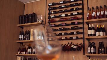 A wine cellar with wooden shelves holding various bottles of wine.