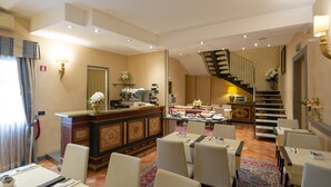 A hotel lobby with a reception desk, seating area, and a staircase. - Davanzati (Florence)