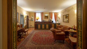 A traditional hotel lobby with a reception desk, seating area, and ornate decor. - Davanzati (Florence)