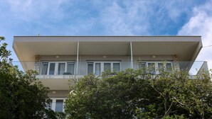 A modern two-story building with a flat roof, large windows, and a balcony. - Aparthotel Pharia (Hvar)