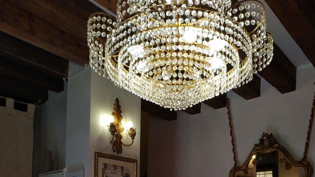 Una escalera con una lámpara de candelabro y un espejo.