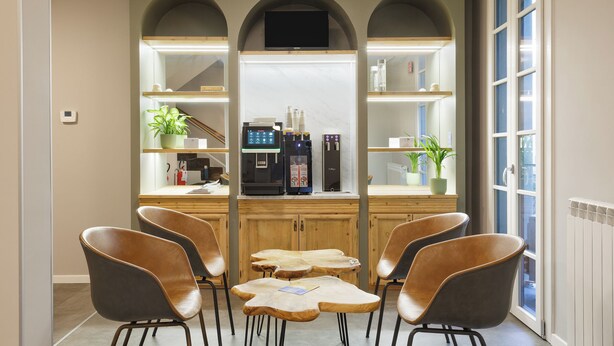 Un'area bar moderna con un bancone, posti a sedere e un televisore.