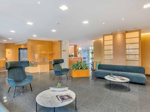 A modern lobby with a reception desk, seating area, and a plant. - SMT EVOLUZIONE S.R.L.  (San Paolo d'Argon)