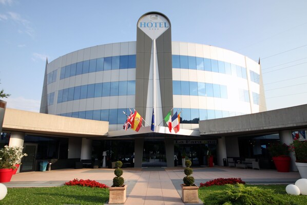 Experience the sleek, contemporary design of this hotel, featuring a distinctive curved facade and beautifully maintained grounds.