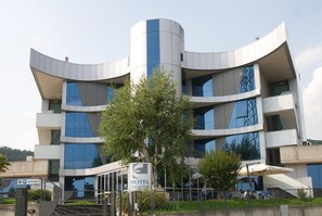 Experience the unique architecture of Hotel Executive, surrounded by lush greenery and natural light.