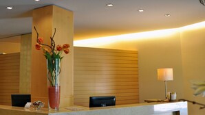 En reception med blomster, en lampe og moderne indretning.