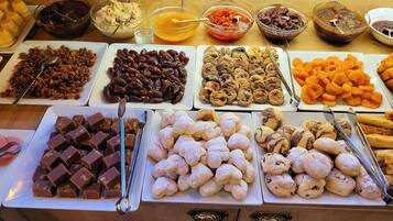 Un assortiment de desserts et de tartinades est présenté sur une table de buffet.