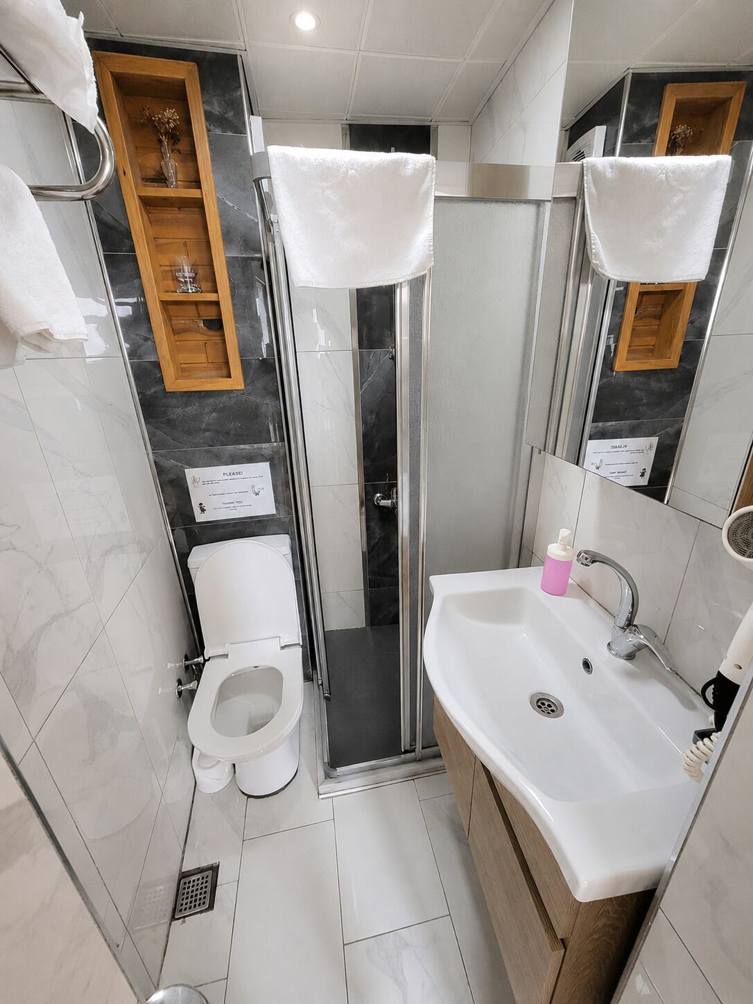 Une salle de bain avec des toilettes, une douche et un lavabo.