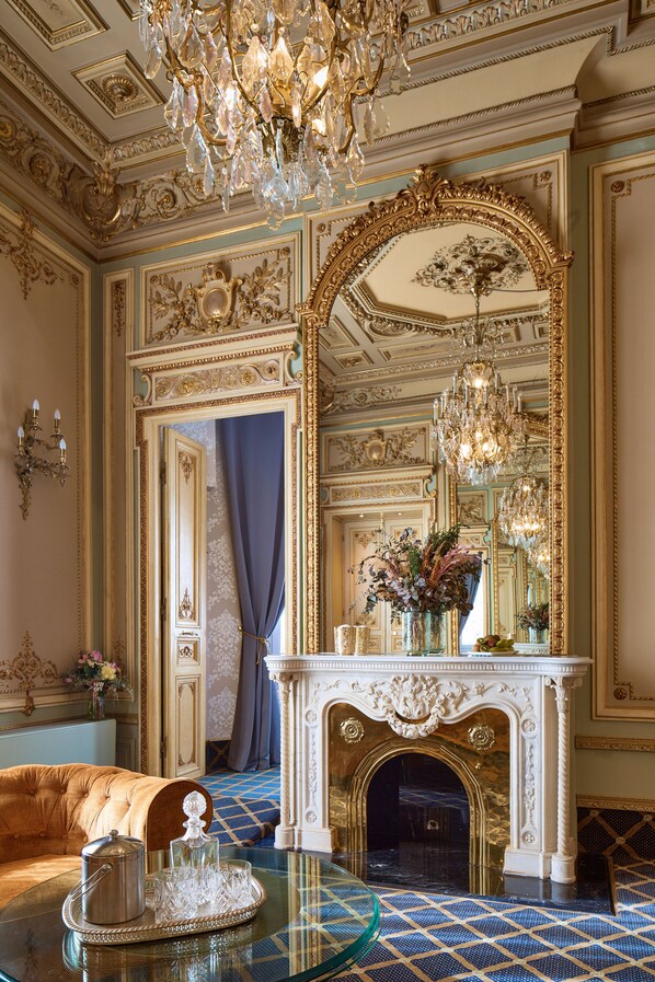 An opulent room with a grand mirror, a fireplace, and a chandelier. - Hotel Continental Palacete (Barcelona)
