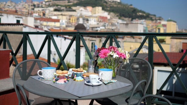 A table with a view of a cityscape and a hill. - Case Così Chiaia (Naples)
