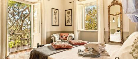 A bedroom with a bed, a large mirror, and two windows.