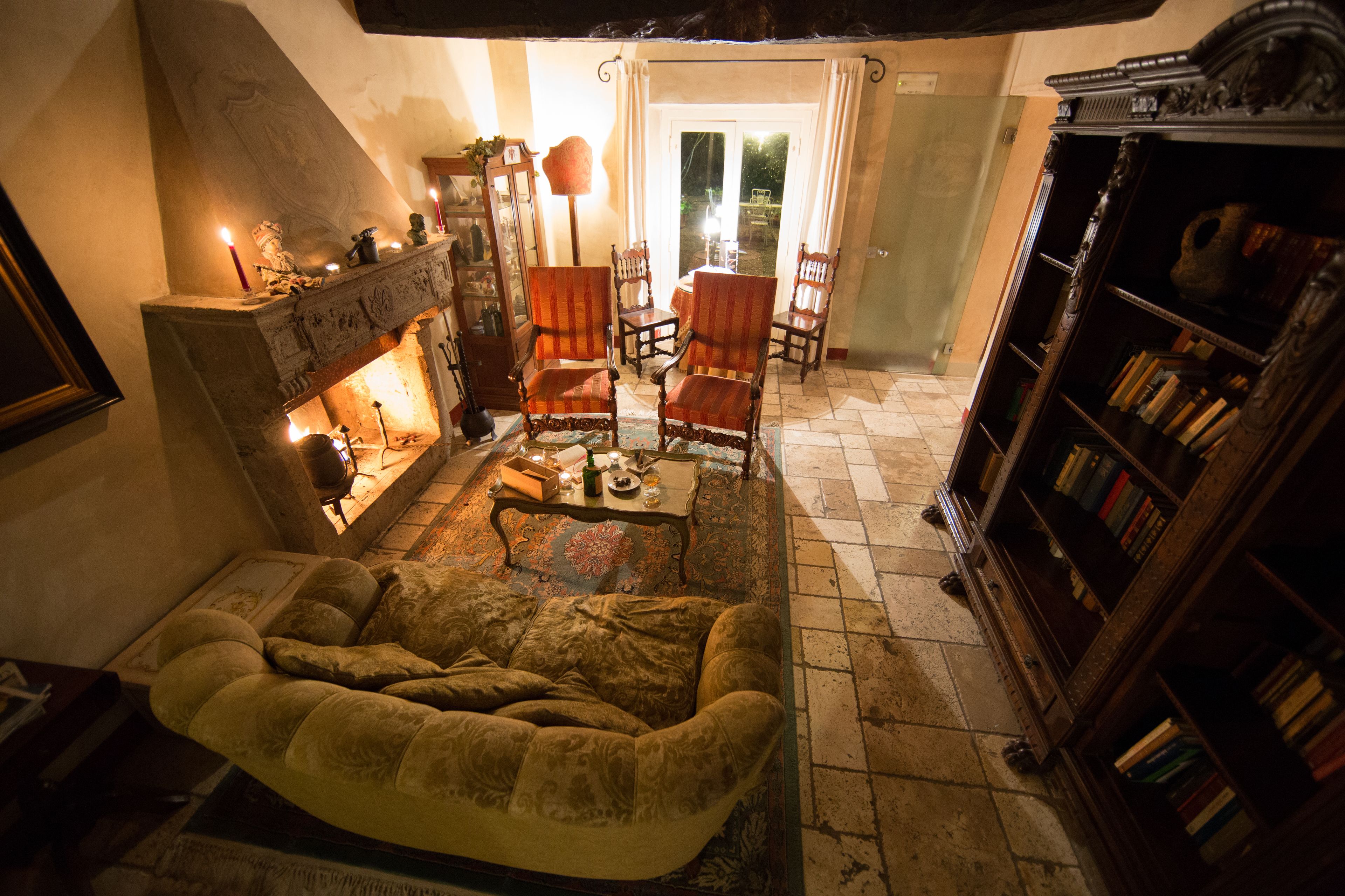 A cozy living room with a fireplace, comfortable seating, and a bookshelf.