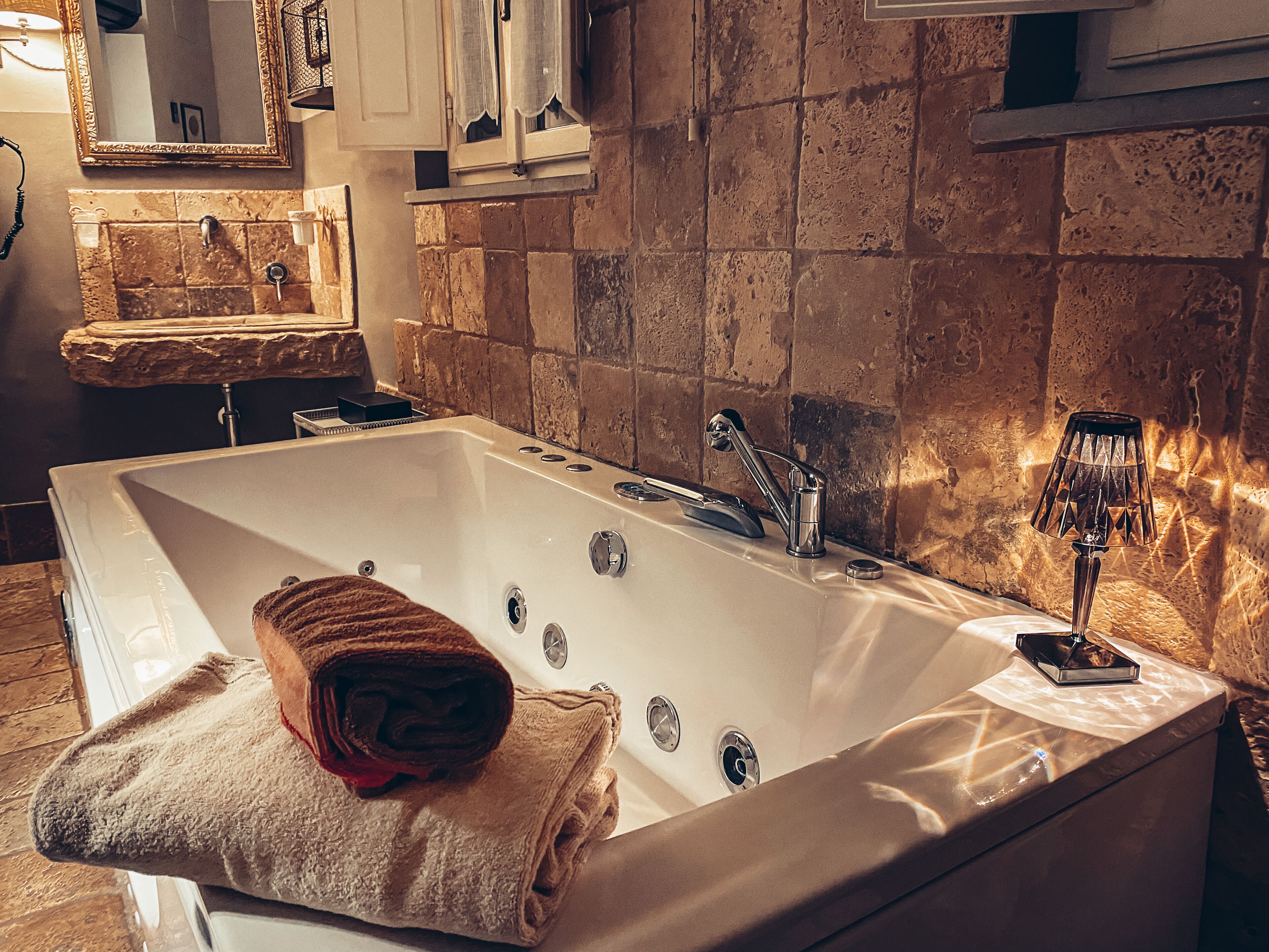 A large, rectangular bathtub with a towel rolled up on the edge.