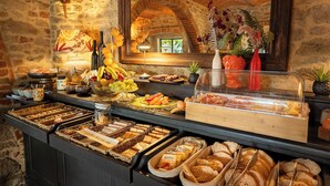 Un bufé con diversos alimentos y un espejo que refleja la arquitectura del salón.