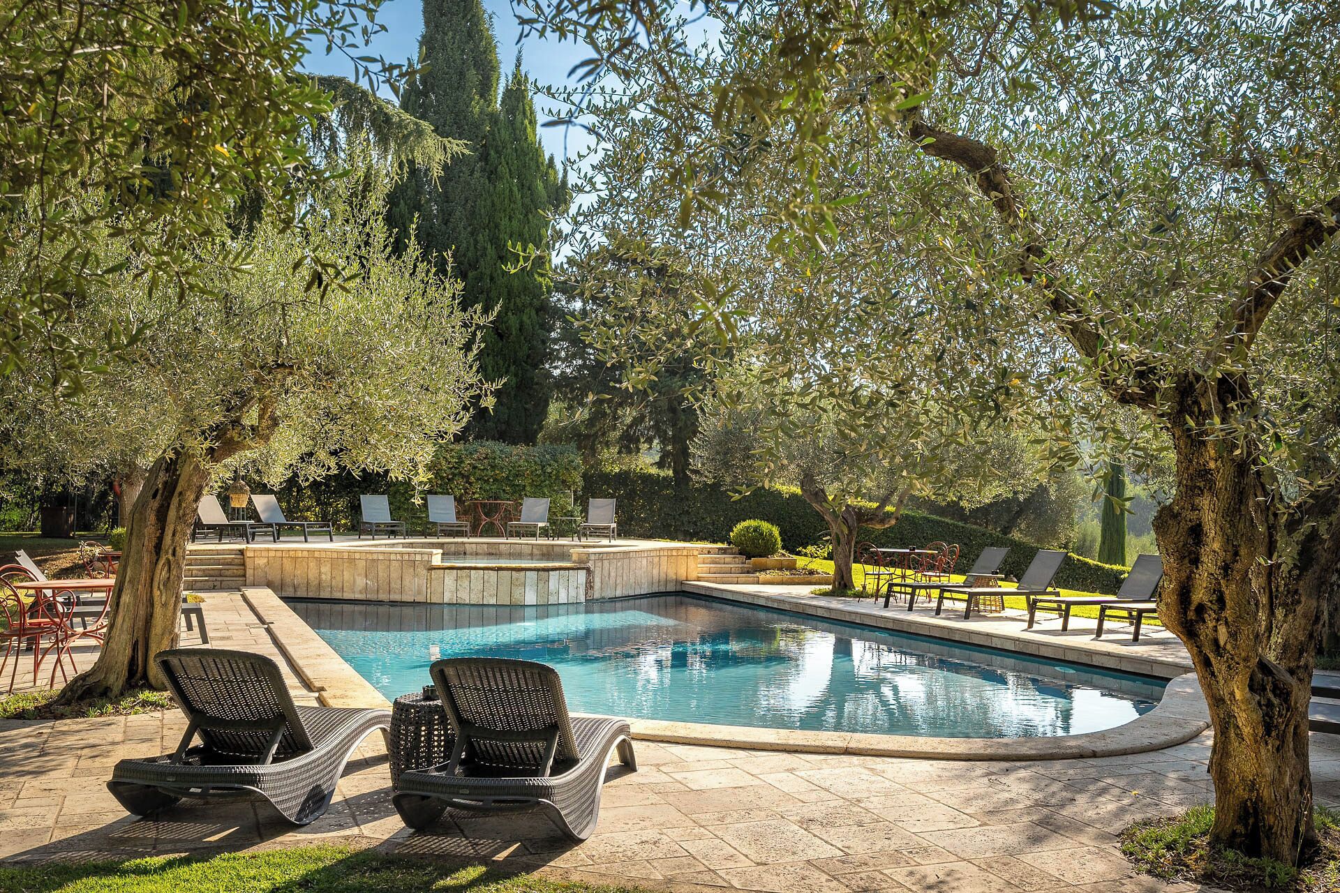 Una piscina cubierta, una piscina al aire libre, tumbonas