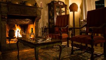 A cozy room with a fireplace, a wooden cabinet, and a red armchair.