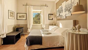 A bedroom with a bed, a nightstand, a lamp, and artwork on the wall.