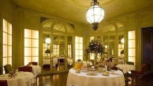 A formal dining room with multiple tables set for service, large windows, and a chandelier. - Palazzo Vecchio (Florence)