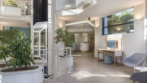 A modern interior with a staircase, a desk, and seating areas.
