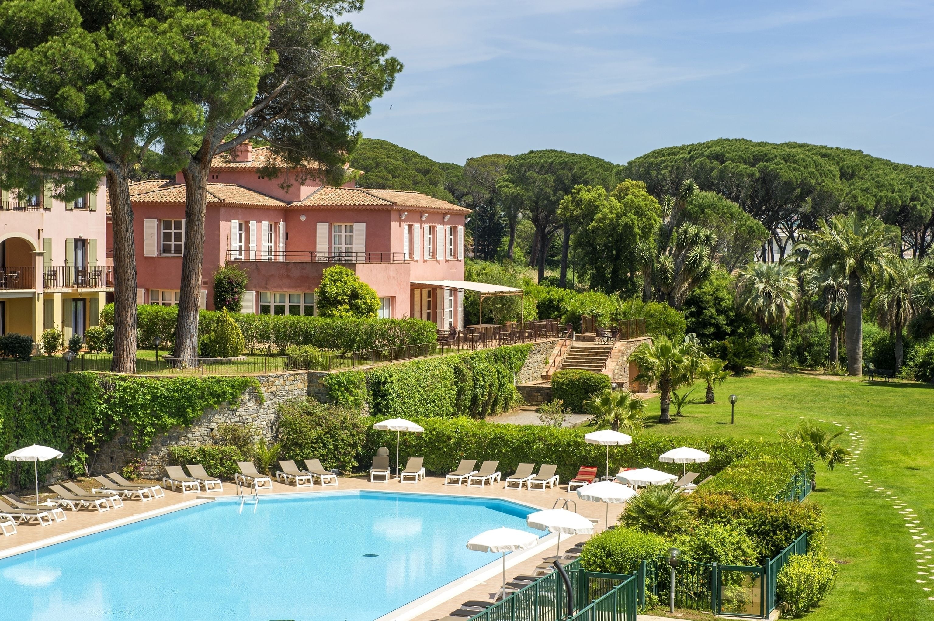 Alberca techada, alberca al aire libre y sombrillas en la alberca