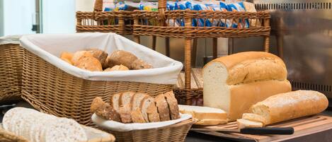 Diversa selección de panes y pasteles exhibidos en una barra.