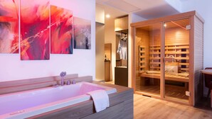 Een moderne badkamer met een ruim bad, een inloopdouche en een glazen inloopkast.