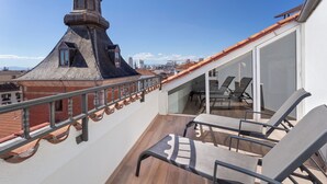 A rooftop terrace with a view of the city skyline, a wooden floor, and a glass door leading to a dining area. - B&B Hotel Madrid Centro Plaza Mayor (Madrid)