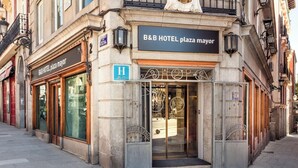 A B&B HOTEL plaza mayor with a shop entrance, a blue handicap accessibility sign, and a metal gate. - B&B Hotel Madrid Centro Plaza Mayor (Madrid)