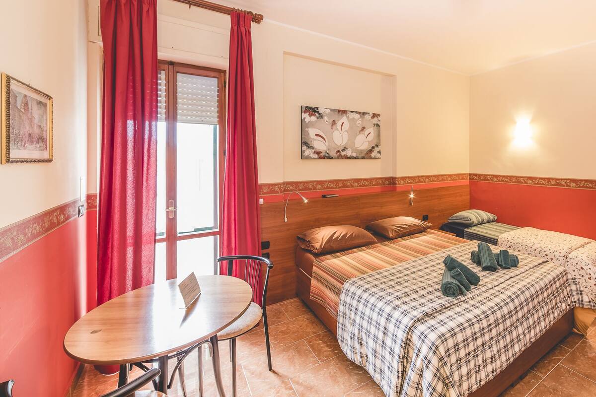 A bedroom with a bed, a table, and a chair.
