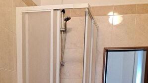 A bathroom with a shower, toilet, bidet, sink, and mirror. - Hotel Bonazzi (Perugia)